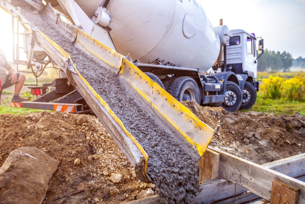 A mixer truck pouring concrete.